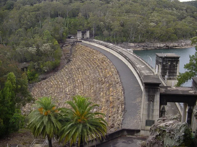The curved Avon Dam wall, its stone embankment and reservoir in 2009.