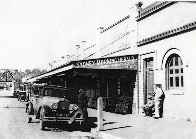 Motor car and people outside a Moss Vale newsagency, dated 1930 in the Society caption.