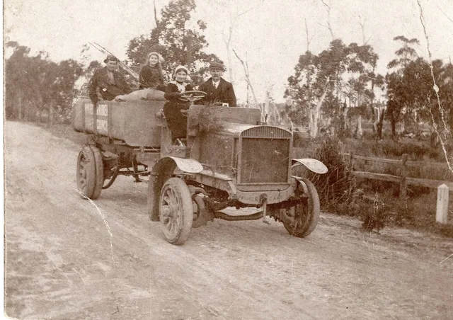 Driver and passengers in an early truck on a country road, captioned Wingecarribee Shire Council truck circa 1917.