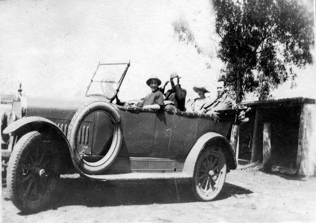 Four adults seated in an open-roofed touring car, Moss Vale, 1921-1926.