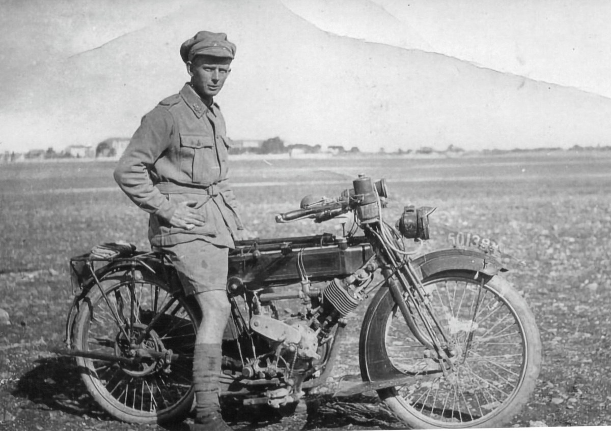 Albert Reynolds standing beside a motorcycle, dated 1917-1919 in the Society caption.