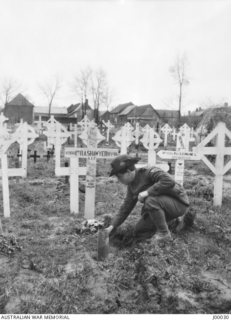 Sergeant Henry Skinner places flowers on Private Roland Shawyer’s grave