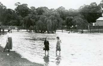Children in a flooded landscape, tentatively identified as Mittagong Rivulet at Bowral