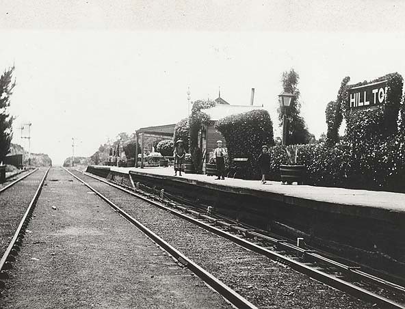 Hill Top railway station platform and tracks, with people on the platform.