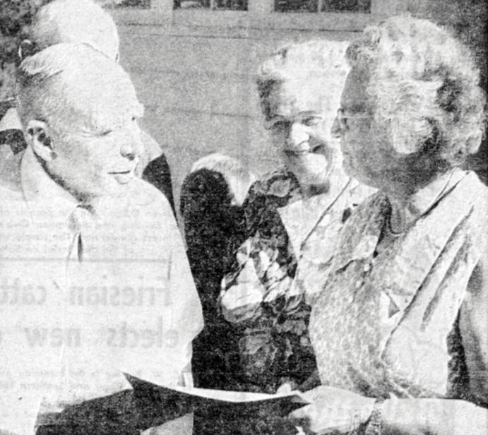 Queenie Moore presents booklets to the museum’s 1,000th visitor, Haille Paine