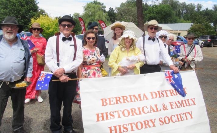 Society volunteers in period costume holding a banner at Berrima